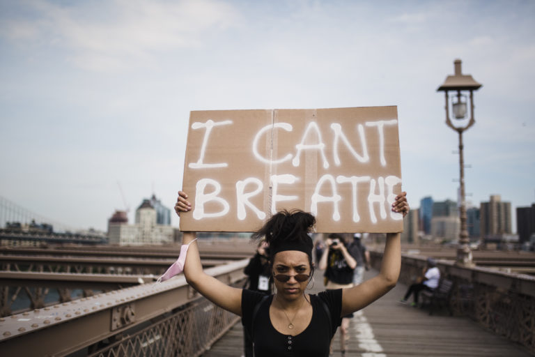 Femme portant un panneau 'I can't breath'